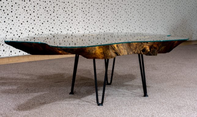 Kaffeetisch aus Holz mit einzigartiger Maserung und schwarzen Metallbeinen.