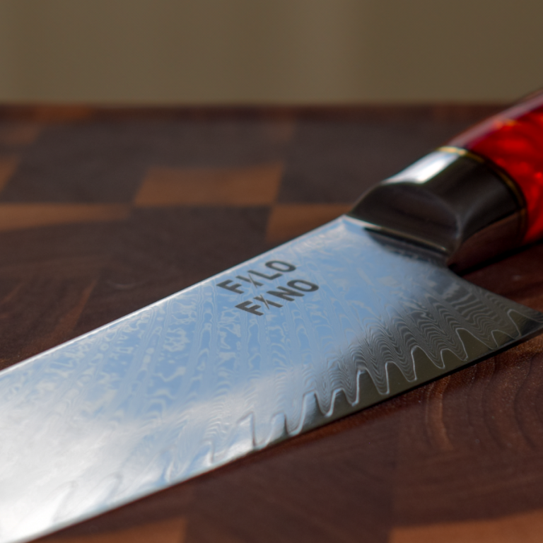 Schneidemesser mit gezahntem Klingenrand auf einem Holzbrett.