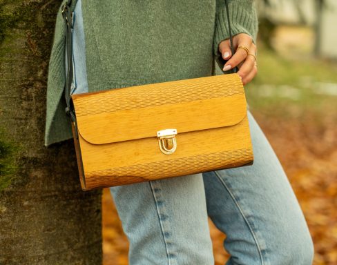 Eine handgehaltene, orangefarbene Clutch mit einem stabilen Verschluss.