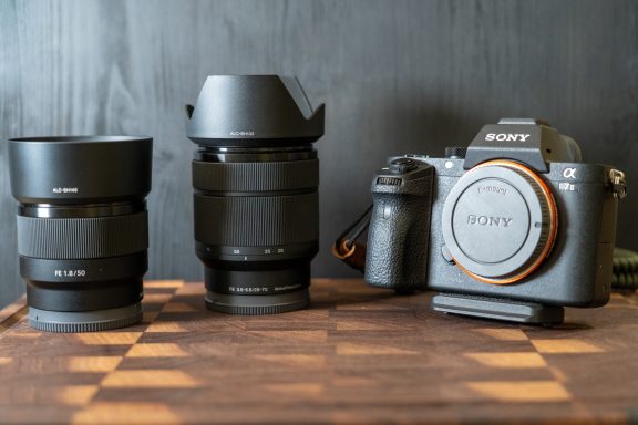 Kamera mit zwei Objektiven auf einem Holzuntergrund.